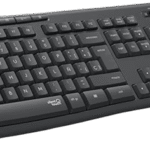 Teclado negro Logitech MK295 y ratón sobre escritorio de madera junto a una planta y monitor