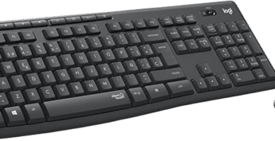 Teclado negro Logitech MK295 y ratón sobre escritorio de madera junto a una planta y monitor